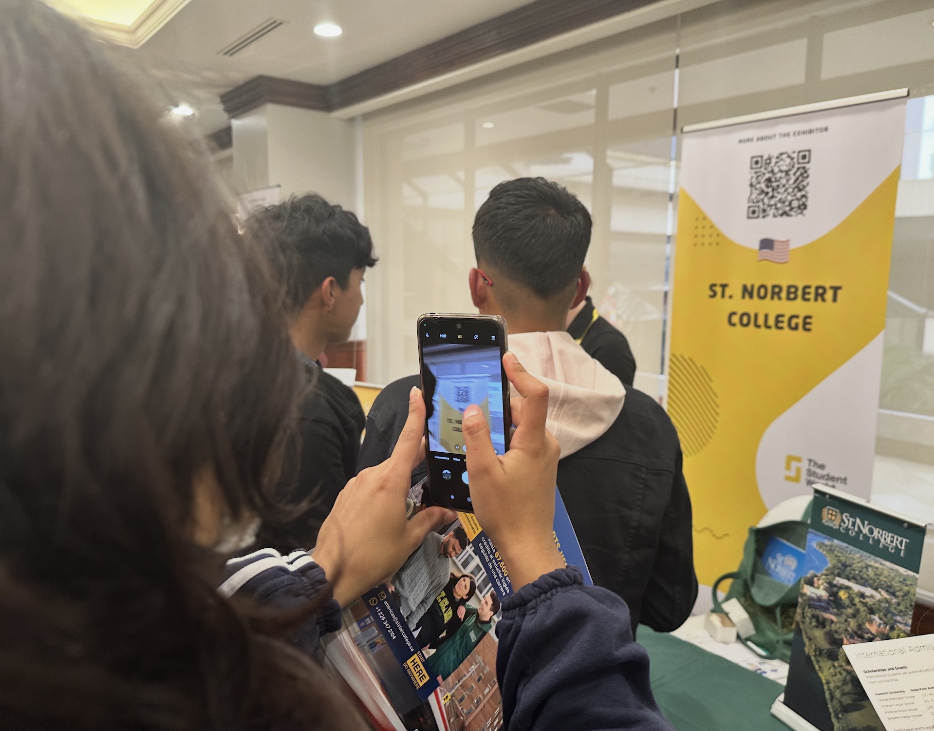 Student scanning QR code on roll-up banner